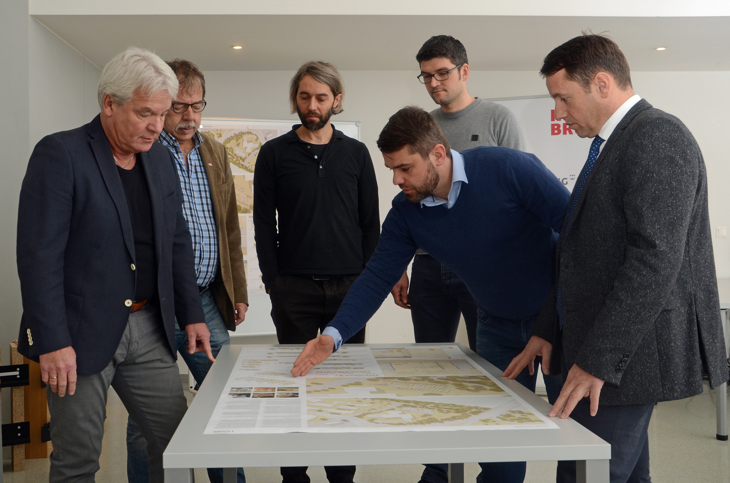 Die Stadträte, Ernst Pechlaner und Gerhard Fritz (v.l.), sowie IIG-Geschäftsführer Franz Danler (r.) ließen sich von Architekt Peter Nußbaumer, Michael Kriegner und Christian Kaufmann (beide Kaufmann Bausysteme GmbH) die Pläne für den mobilen Kindergarten erläutern.