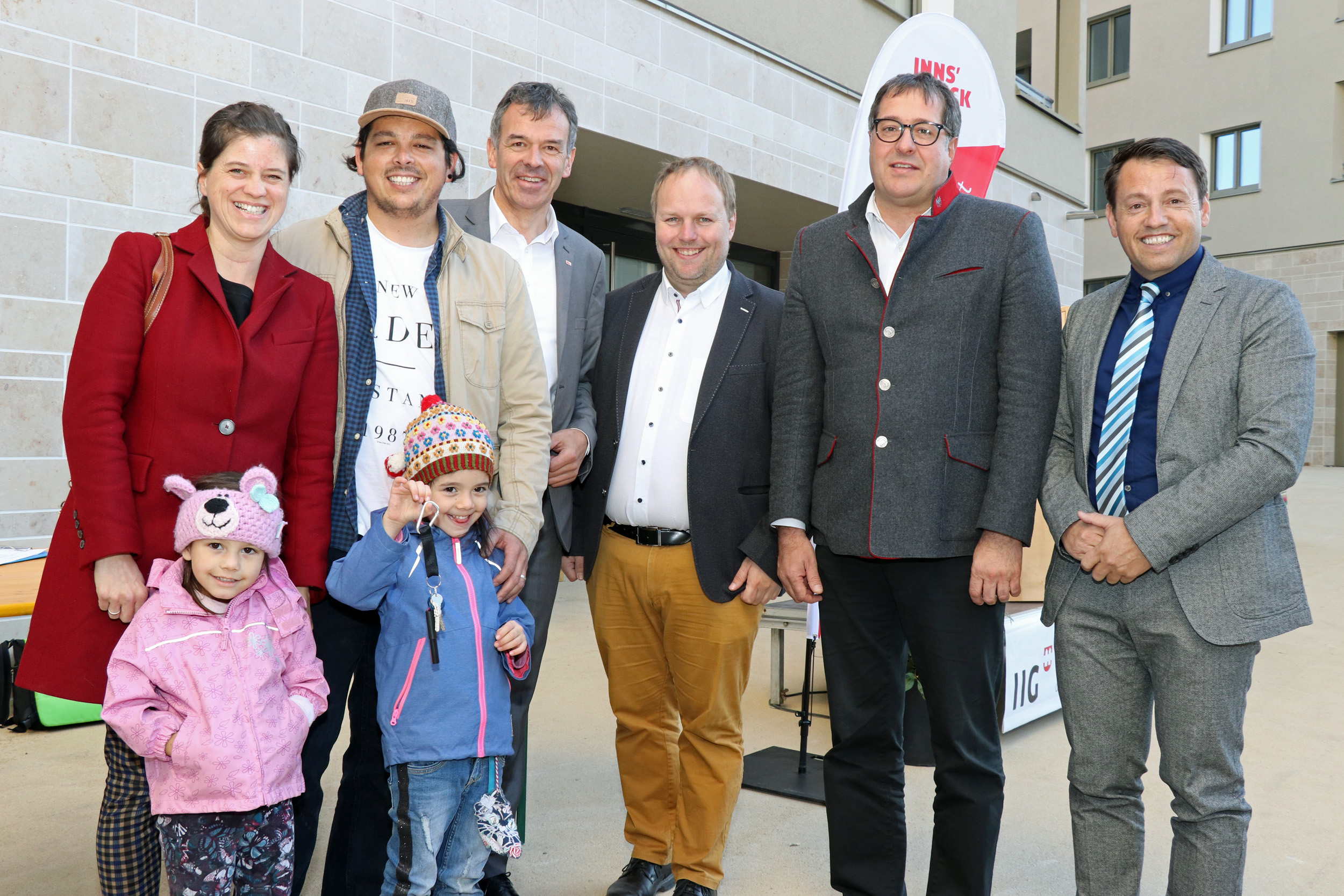 Eine junge Familie freut sich über ihre neue Wohnung in der Bienerstraße 10a. Bürgermeister Georg Willi (3. v. l.), Bauausschuss-Vorsitzender Gemeinderat Lucas Krackl (3. v. r.), Vizebürgermeister Franz X. Gruber (2. v. r.) und IIG-Geschäftsführer Franz Danler (r.) überreichten den Schlüssel.